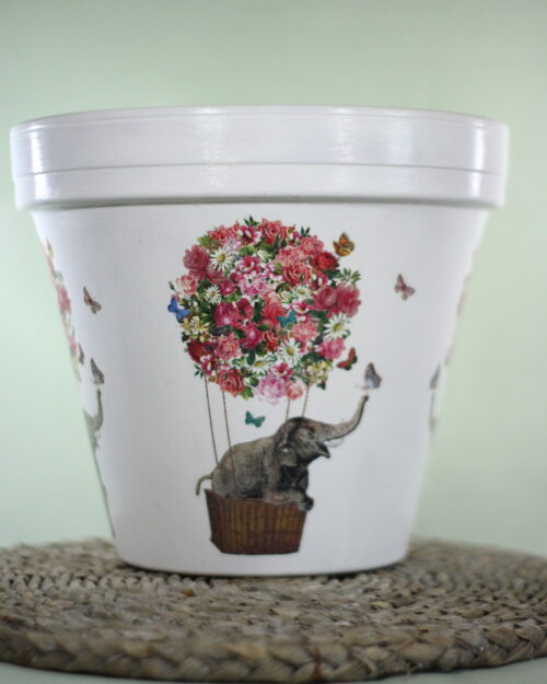 Elephant pot in a hot air balloon covered in flowers with a green background