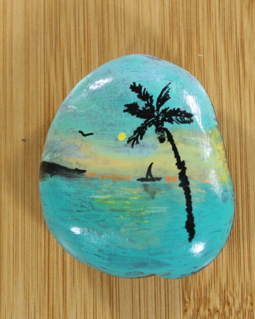 palm tree, sunset on the sea painted onto a pebble
