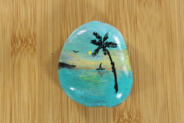 palm tree, sunset on the sea painted onto a pebble